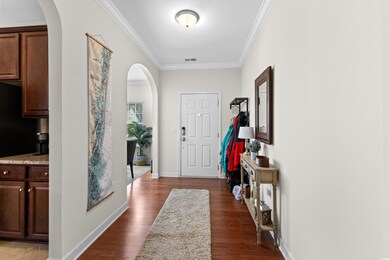 Foyer entrance with ornamental molding and dark ha