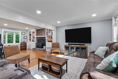 Living room featuring a brick fireplace, crown mol