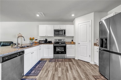 Kitchen with a sink, light wood finished floors, s