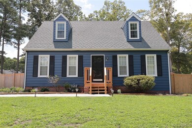 New england style home featuring a front lawn