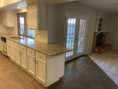 Kitchen with light stone countertops, sink, white 