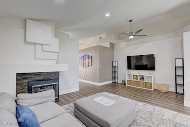Living room featuring lofted ceiling, a ceiling fa
