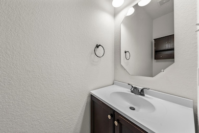 Bathroom with vanity and a textured wall