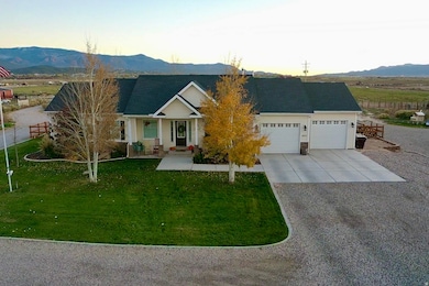 View of front of house with a mountain view, driveway, a porch, and a lawn