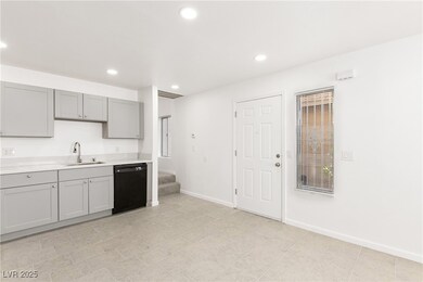 Kitchen with dishwasher, a sink, gray cabinetry, l