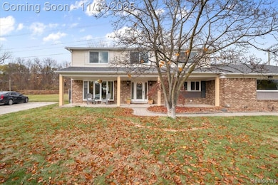 Traditional-style house with brick siding, a porch, and a front yard