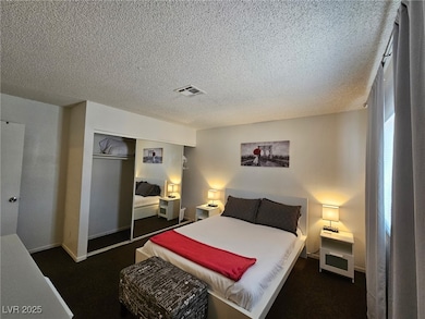 Bedroom featuring a closet, a textured ceiling, and carpet floors