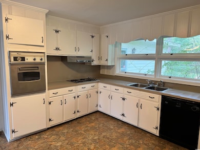 Kitchen with sink, white cabinetry, stainless stee