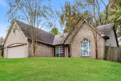 View of front of house featuring brick siding, a shingled roof, and a garage