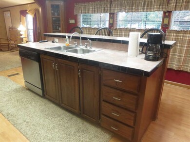Lots of windows in eat in  kitchen with bar.
