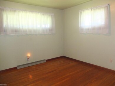 Bedroom 1 with hardwood flooring.