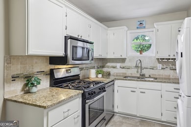 Kitchen boasts White Cabinets, Granite Countertops, and Stainless Steel Appliances