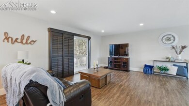 A bright & spacious Great Room with large windows that bathe the space in natural light, while sliding doors lead to a front deck offering magnificent mountain views.