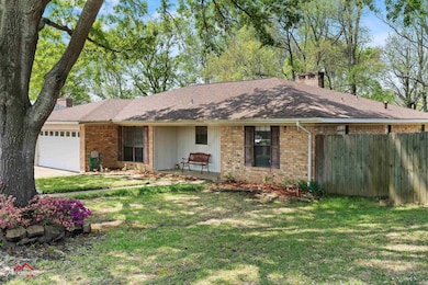 Single story home featuring fence, an attached garage, a front lawn, brick siding, and a chimney