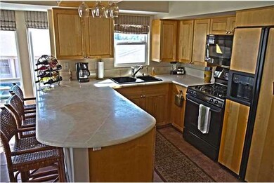Open kitchen with natural stone counters and bar s