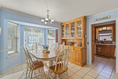 Dining room with light tile patterned floors, a chandelier, and ornamental molding