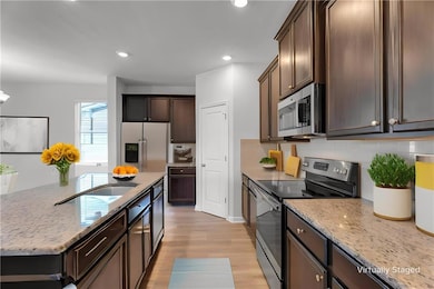 Kitchen with light stone counters, stainless steel