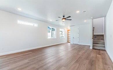 Unfurnished living room featuring stairway, light