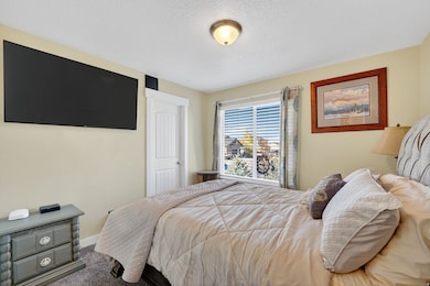 Carpeted bedroom with a textured ceiling and baseboards