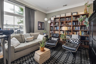 Sitting room with ornamental molding and carpet flooring