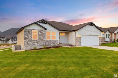 Craftsman inspired home featuring board and batten siding, stone siding, an attached garage, driveway, and a yard