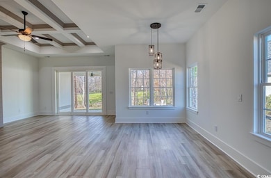 Unfurnished dining area with plenty of natural light, beam ceiling, light wood-style floors, ceiling fan, and coffered ceiling