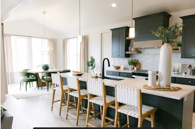 Kitchen with a kitchen breakfast bar, decorative light fixtures, a kitchen island with sink, decorative backsplash, and recessed lighting