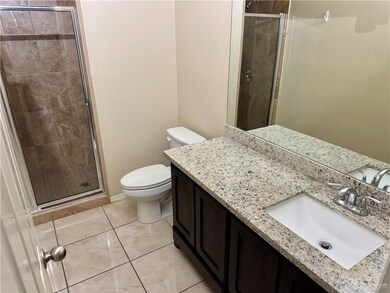 Bathroom with a stall shower, vanity, toilet, and tile patterned floors
