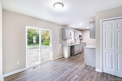 Kitchen with gray cabinets, light wood-style floors, and light stone countertops