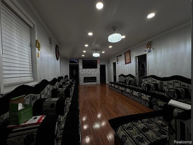 Cinema room with ornamental molding, recessed lighting, dark wood-type flooring, and a fireplace