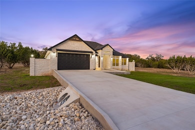 View of front of house featuring a garage, a lawn