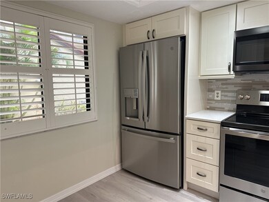 Kitchen with white cabinets, appliances with stain