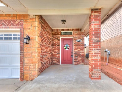 View of exterior entry featuring brick siding and a garage