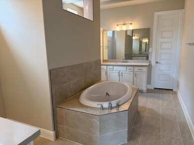 Full bathroom featuring vanity, a garden tub, and