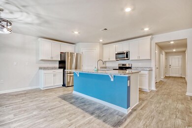Kitchen featuring stainless steel appliances, white cabinets, a kitchen bar, light wood-type flooring, and recessed lighting