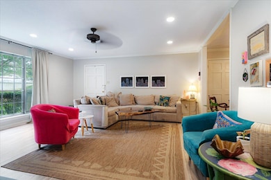 Living room featuring a ceiling fan, ornamental molding, recessed lighting, and light wood finished floors