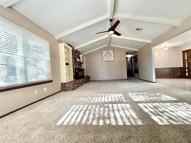 Unfurnished living room featuring wooden walls, a 