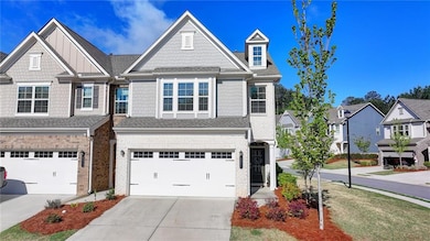 View of property with an attached garage, roof wit