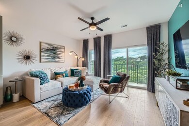Living room with a ceiling fan and light wood-typ