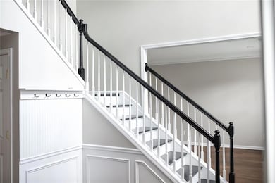 Stairs featuring crown molding, wood finished floo