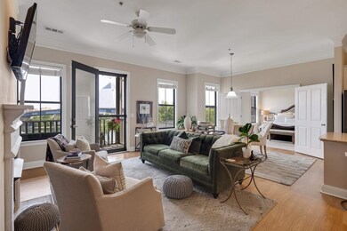 Living room with light wood-style floors, a ceiling fan, and crown molding