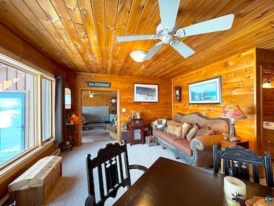 Dining area featuring wood walls, ceiling fan, car