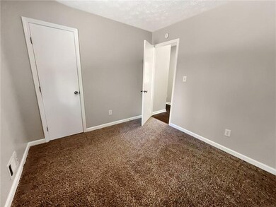 Unfurnished bedroom with dark colored carpet, base