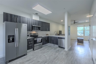 Kitchen featuring stainless steel appliances, lig