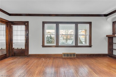 Empty room with dark hardwood / wood-style flooring and crown molding