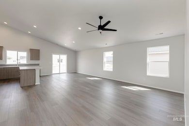 Unfurnished living room featuring dark wood finished floors, ceiling fan, high vaulted ceiling, and recessed lighting
