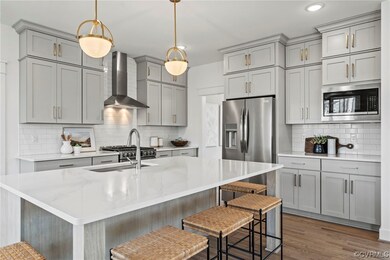 Kitchen featuring wall chimney exhaust hood, appli