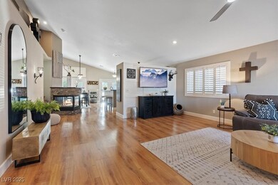 Living room with vaulted ceiling, wood finished floors, ceiling fan, and recessed lighting