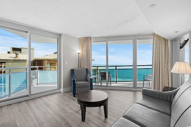 Living room featuring floor to ceiling windows, a water view, and light hardwood / wood-style floors