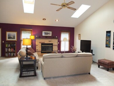 Open great room with vaulted ceiling, skylights an